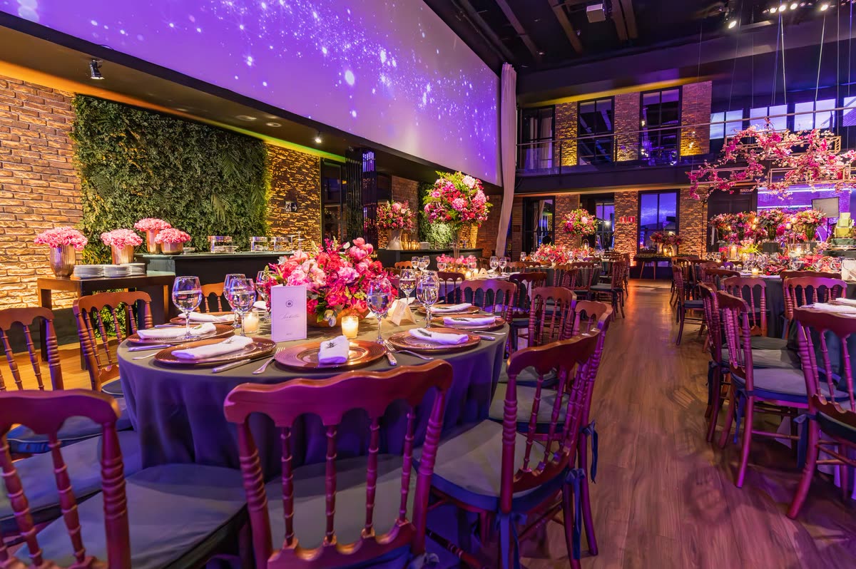 Banquet hall set for a gala dinner under purple light