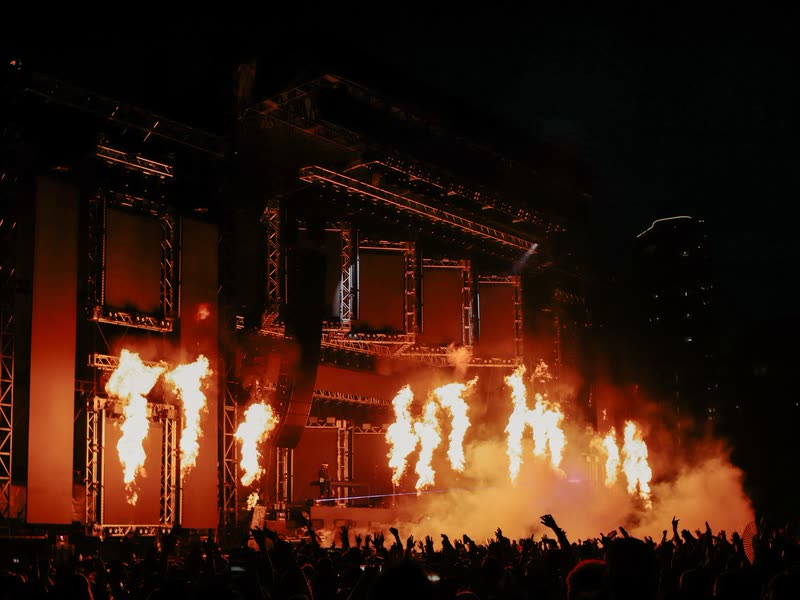 Flame jets across a stage set at a night-time show