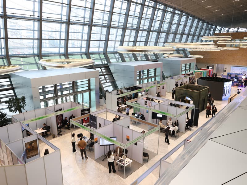 Exhibition hall with stands and visitors, seen from above