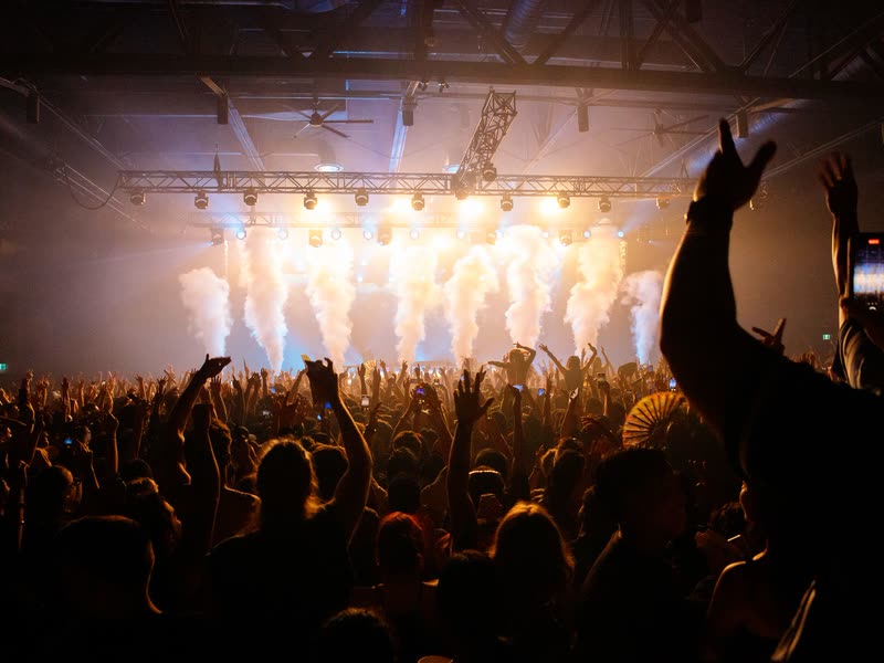 Crowd under stage lights in an industrial hall